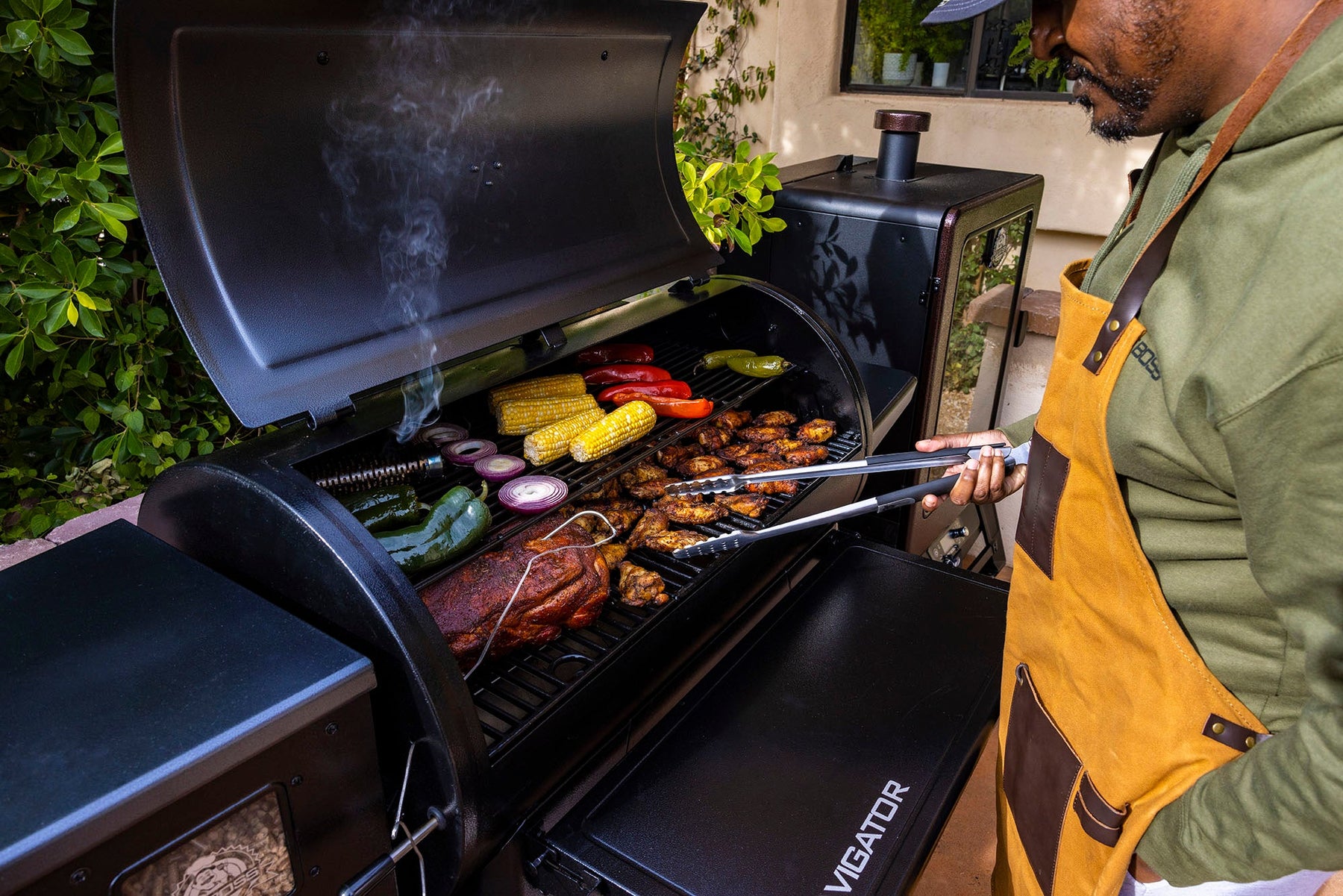 Pit Boss navigator grill with a variety of meat and vegetables 