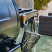 Green Pit Boss grill with wooden tool holder and black gloves on top.