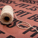 Natural jute twine spool on branded background.