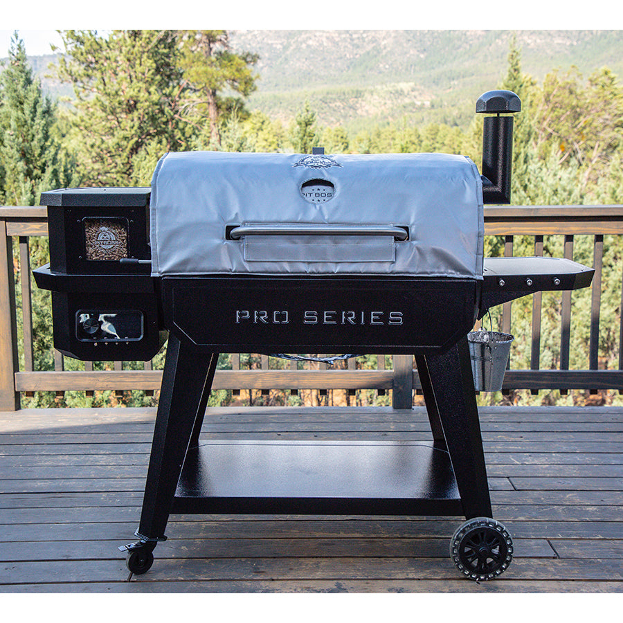 Black Pit Boss Pro Series pellet grill with silver cover, outdoor setting.