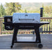 Black Pit Boss Pro Series pellet grill with silver cover, outdoor setting.