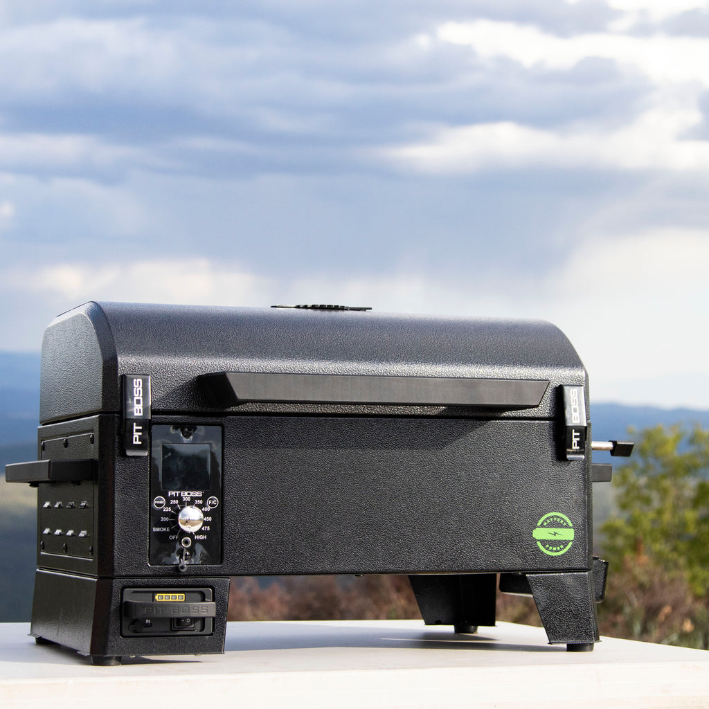 Compact black tabletop pellet grill with digital control panel, sturdy handle, and side vents. Ideal for outdoor cooking.