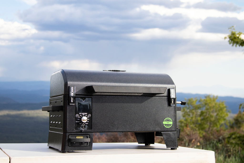Compact black tabletop pellet grill with digital control panel, sturdy handle, and side vents. Ideal for outdoor cooking.