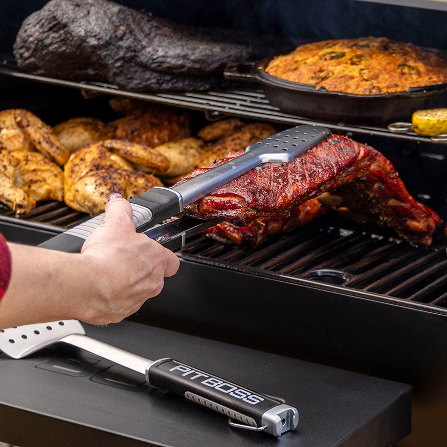 Pit Boss Grills Sportsman 850 Wood Pellet Grill, grilling rack of ribs on smoker with bbq tongs