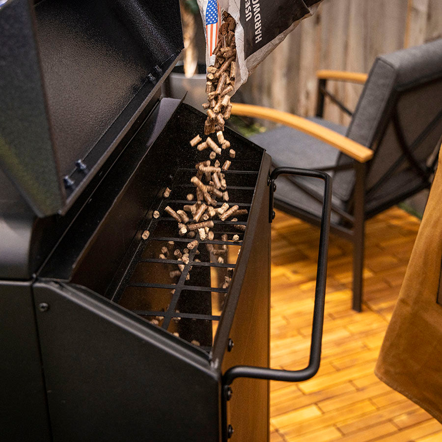Pit Boss Navigator 3 Series Vertical Smoker, hardwood bbq pellets being poured into 50 lb hopper