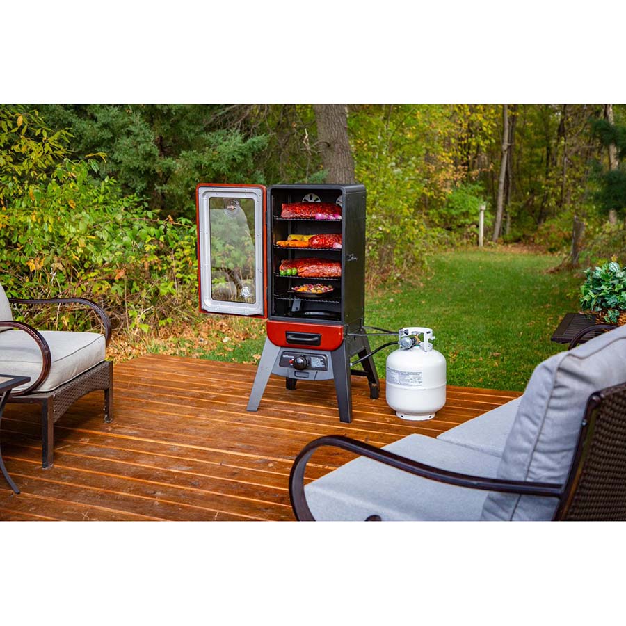 vertical smoker on backyard porch with food on all racks