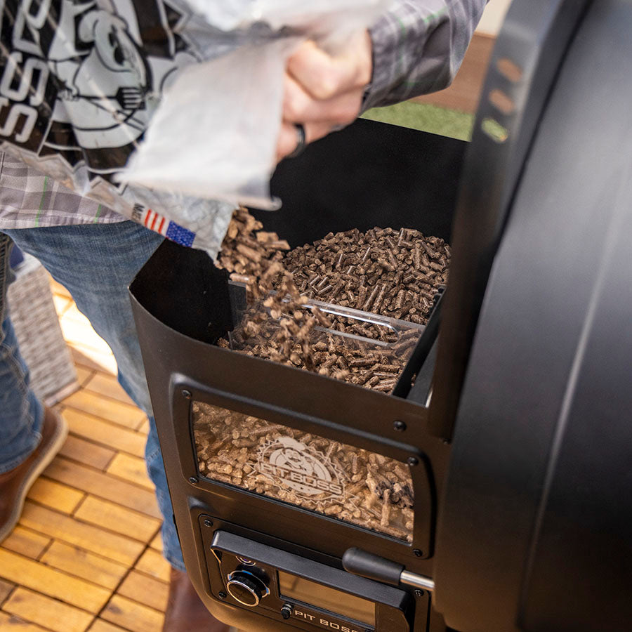 Pit Boss Hardwood BBQ Pellets Being Poured Into Wood Pellet Grill Hopper