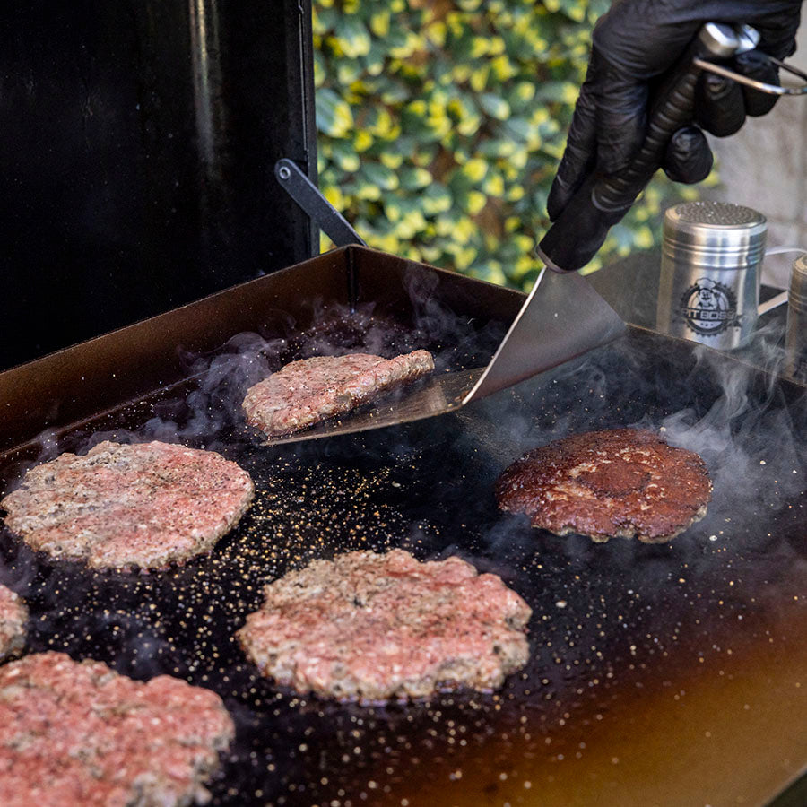 Close up of burger being flipped by Pit Boss big head spatula.