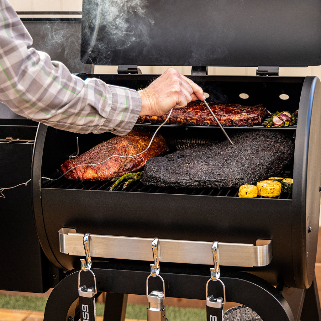 Pit Boss Carbon Series 500 wood pellet grill shown from a front angled view with lid open, displaying cooking grates, grilling surface, and meat probes