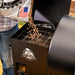Pouring Pit Boss hardwood pellets into the Carbon Series 700 wood pellet grill hopper