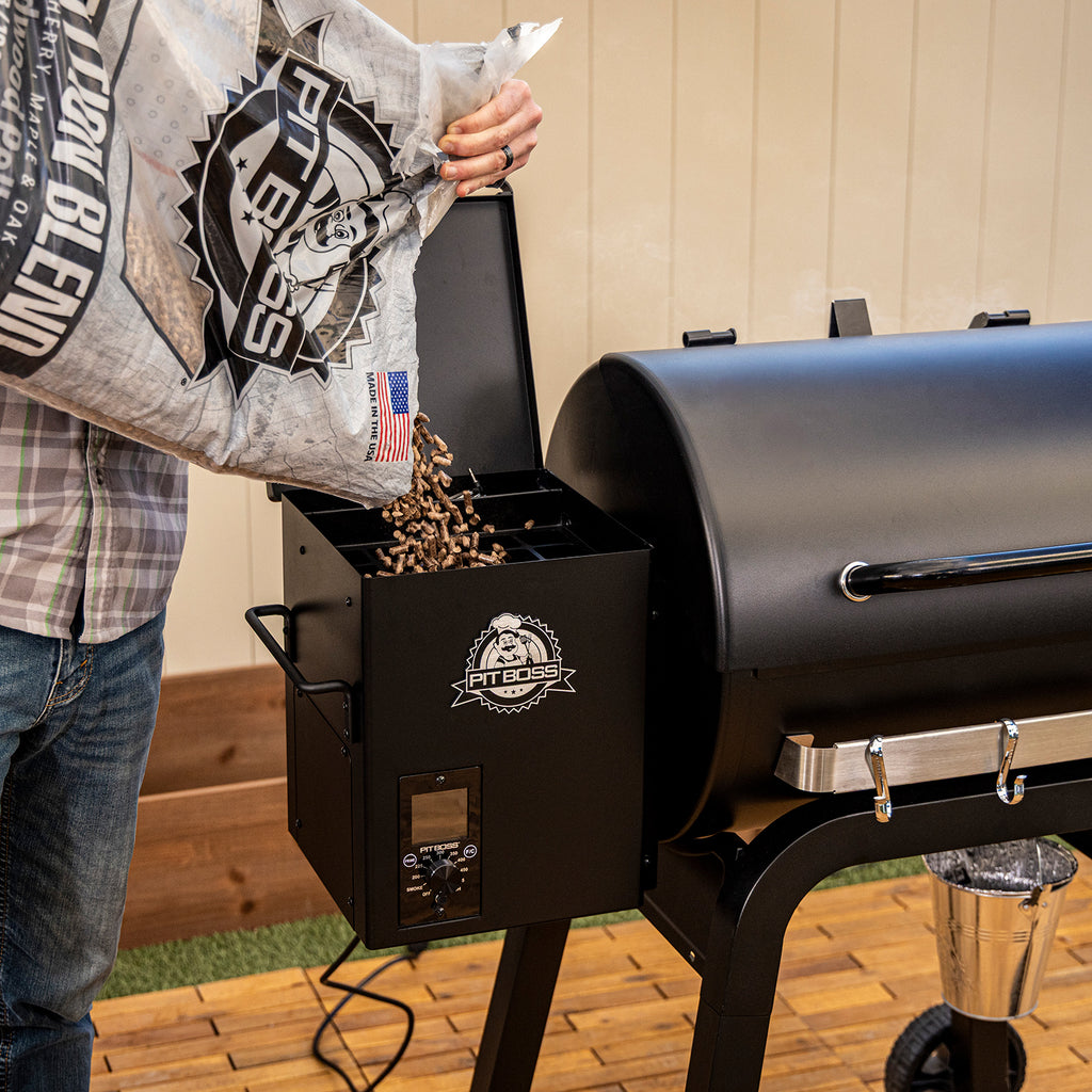 Pouring Pit Boss hardwood pellets into the Pit Boss Carbon Series 500 wood pellet grill