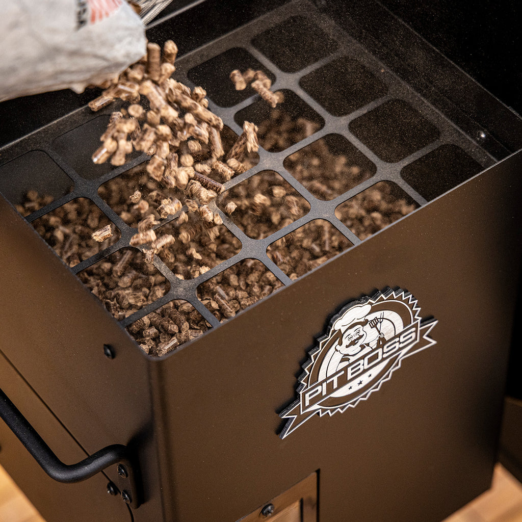 Pouring Pit Boss hardwood pellets into the Carbon Series 500 wood pellet grill hopper