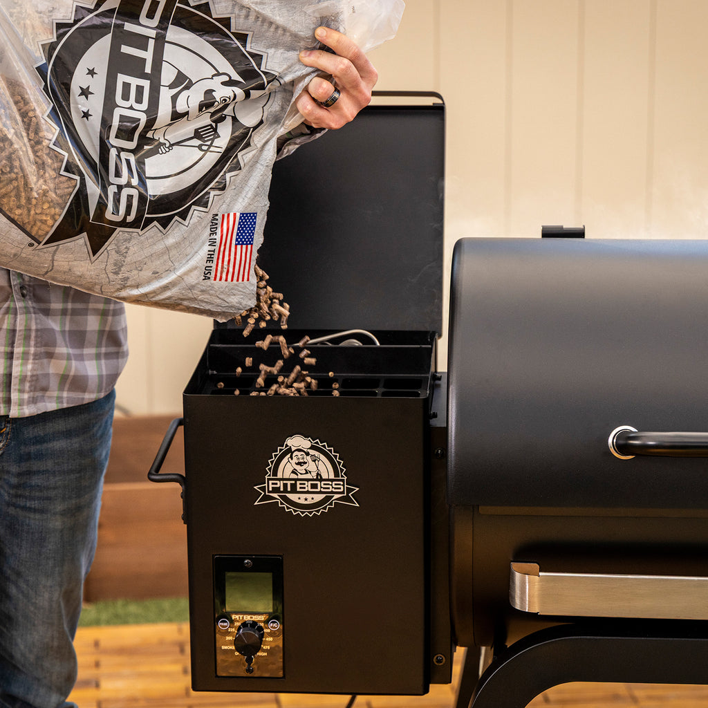 Pouring Pit Boss hardwood pellets into the Pit Boss Carbon Series 700 wood pellet grill