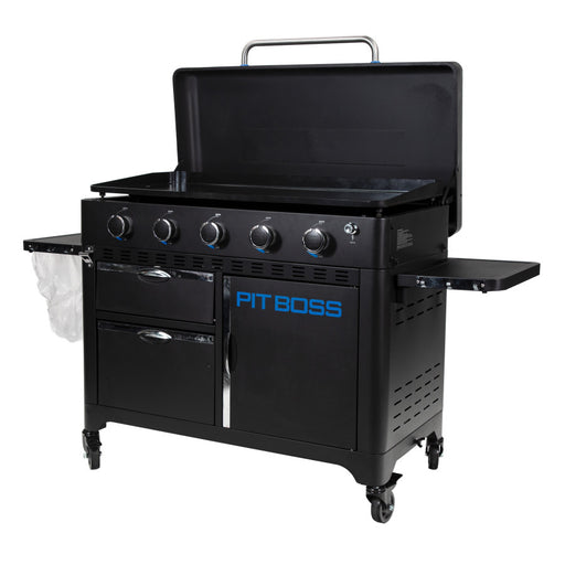 lifestyle_3, Black griddle with bright blue and silver accents with large blue "pit boss" logo. Side angle view. Grill hood open