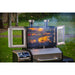 Smpoker doors open shown with meats and veggies on all three levels of the grilling rack. Grill located in a backyard.