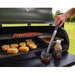 lifestyle_1, Silver tongs with black handle and small pit boss logo. Pictured dipped into texas mesquite bbq sauce