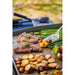Up close of veggies and meats being cooked on the griddle.