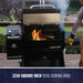 lifestyle_2, Silver and black grill/smoker with Pit boss logo and white lettering. Shown on backyard porch with meat and veggies inside