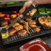 Black grill with chicken, corn, peppers, and vegetables cooking.
