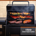 Black Odessa 3-tiered oven-style grates grill with smoking meats and vegetables.