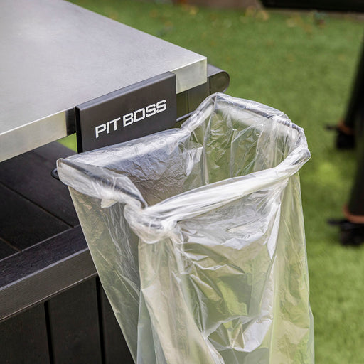 Clear plastic bag attached to a black "PIT BOSS" trash can holder on a grill.