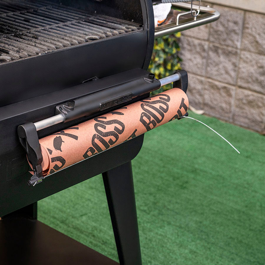 Black BBQ grill with mounted paper towel holder, branded "BOSS" roll.