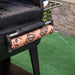 Black BBQ grill with mounted paper towel holder, branded "BOSS" roll.