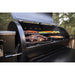 Black pellet grill with open lid, cooking meat and vegetables.