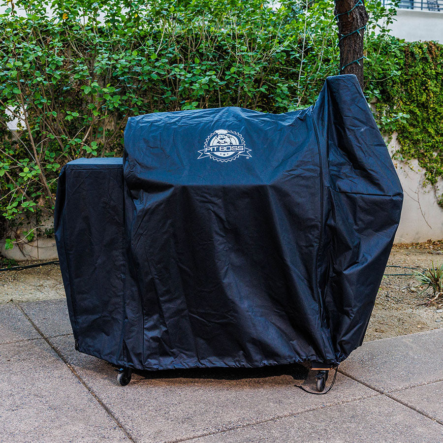 Blue Pit Boss grill cover on wheels, outdoor use.