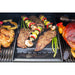 Black grill tray with assorted grilled meats and vegetables.