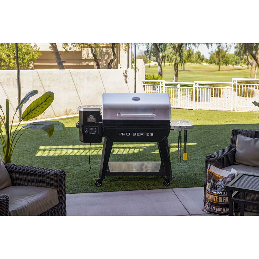 Black and silver Pro Series electric grill on wheels, outdoors on grass.