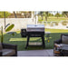 Black and silver Pro Series electric grill on wheels, outdoors on grass.