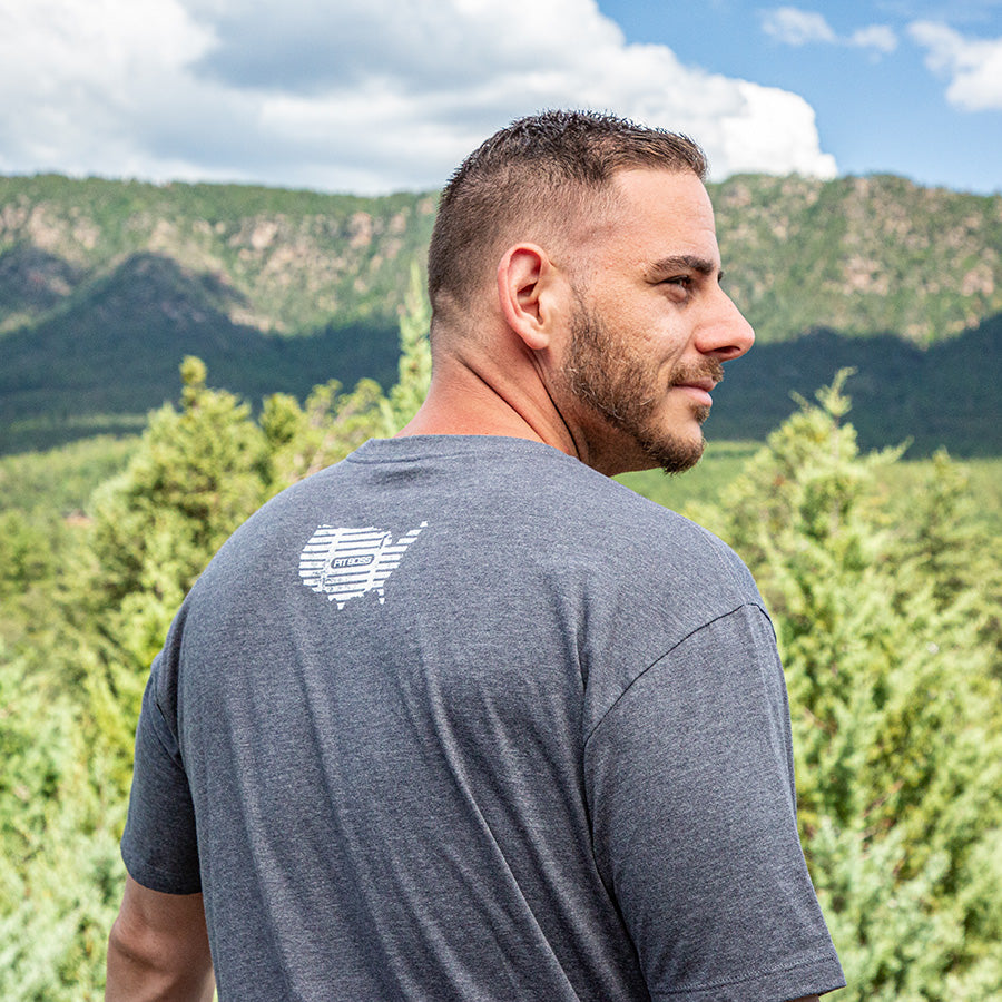 Gray t-shirt with "FITNESS" logo on back, outdoors.