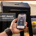 Smart black grill with Wi-Fi and Bluetooth connectivity, controlled via smartphone app.