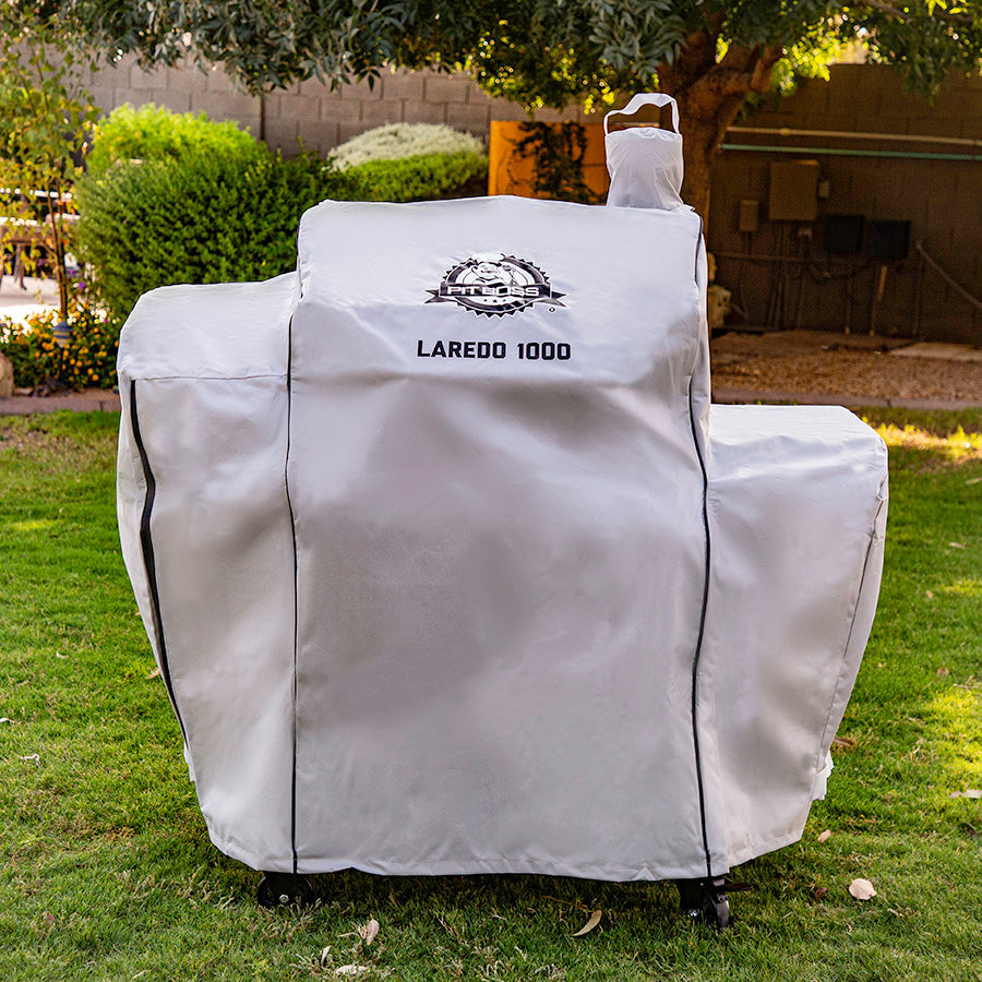 White Laredo 1000 grill cover on grass.