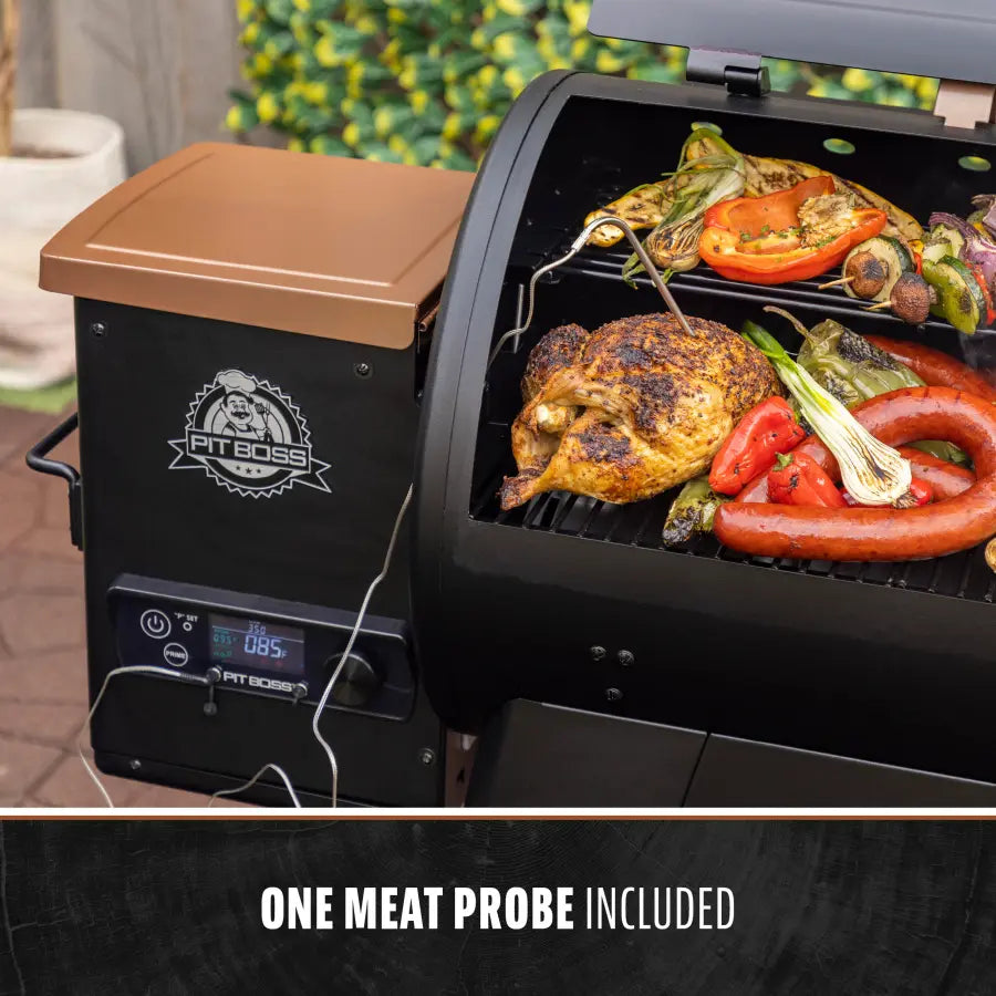 Black Pit Boss electric grill with chicken, vegetables, and sausages cooking. One meat probe included.