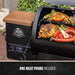 Black Pit Boss electric grill with chicken, vegetables, and sausages cooking. One meat probe included.