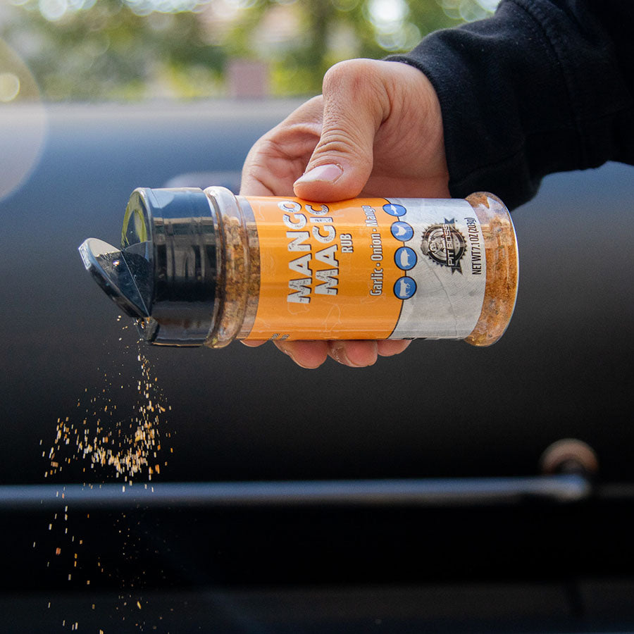 Orange "Mango Magic Rub" seasoning container being shaken.