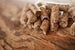 Brown cylindrical pet treats stacked on a wooden surface.