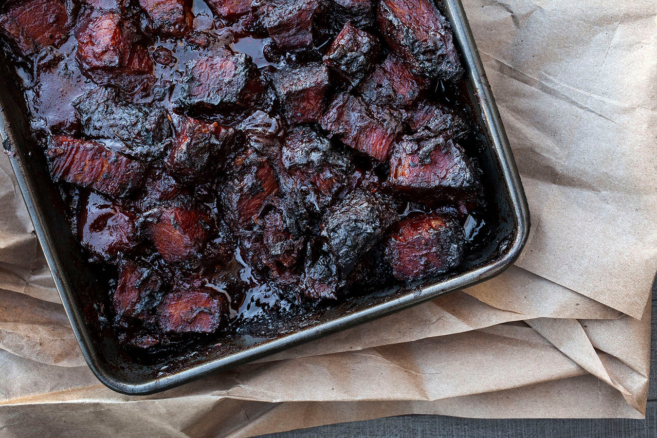 BBQ Brisket Burnt Ends in pan braised in sauce on parchment paper