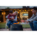 Black Pit Boss portable fire pit with family enjoying warmth outdoors.