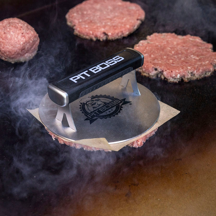 Black Pit Boss burger press on grill with patties cooking.