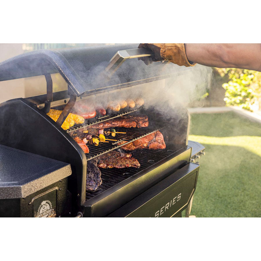 Green Camp Chef Series portable charcoal grill with food cooking.