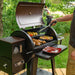 Black Pit Boss pellet grill with open lid, cooking chicken, corn, and vegetables.