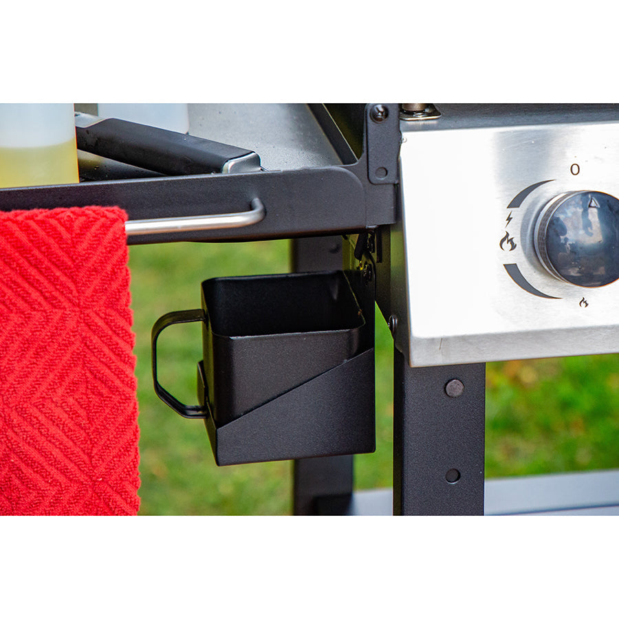 Outdoor grill with red towel and cup holder.