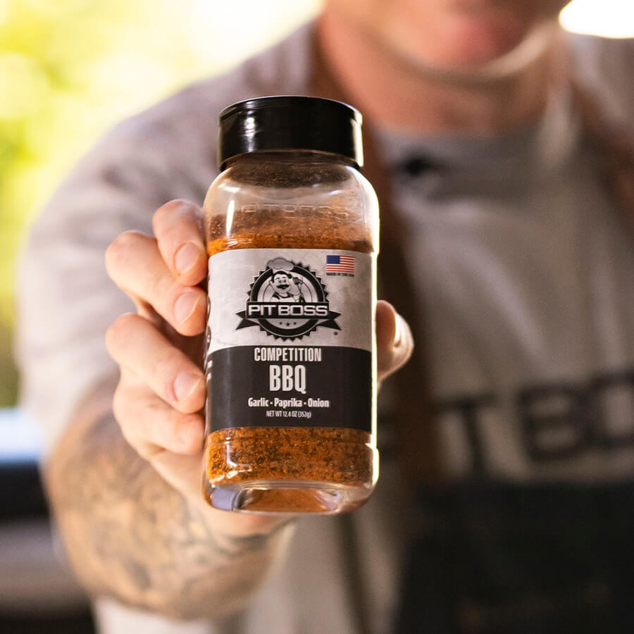 Clear glass bottle of Pit Boss Competition BBQ spice blend with garlic, paprika, and onion.