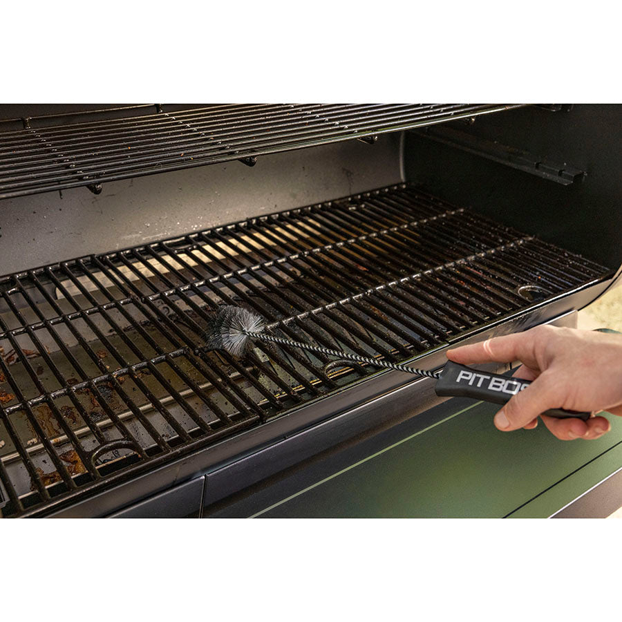Close up of the chimney/burn pot scrubber being used to clean grill racks on barbecue.