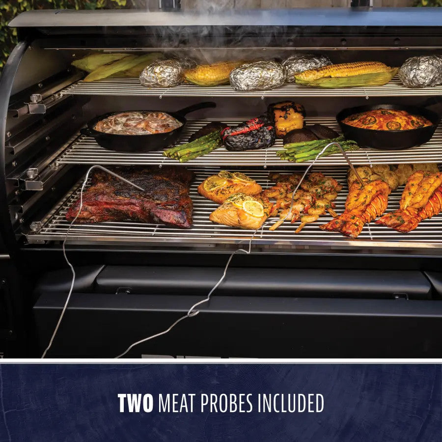 "Black multi-level smoker with meats, vegetables, and seafood cooking, two meat probes included."