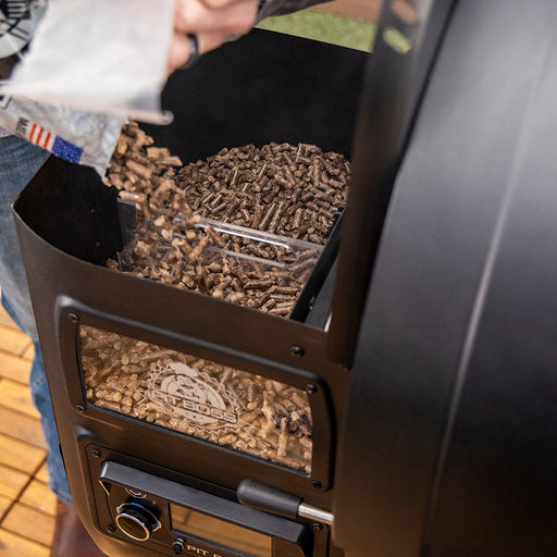 Pit Boss Competition Series 1250 Wood Pellet Gril. Black grill with silver accents. Hood open.