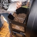 Black Pit Boss pellet grill with person adding wood pellets.